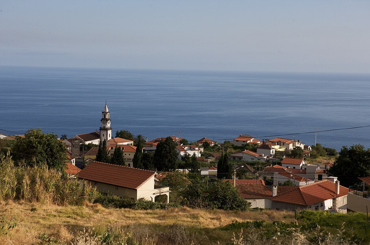 Kirche und Hanghäuser von Arco da Calheta über dem Meer, ein Blick beim Spaziergang durch den Ort.