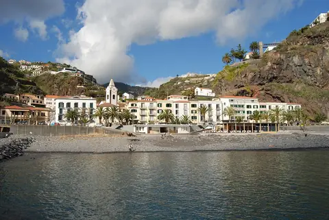 Les façades blanches sous les falaises de Ponta do Sol bordent la promenade en front de mer.